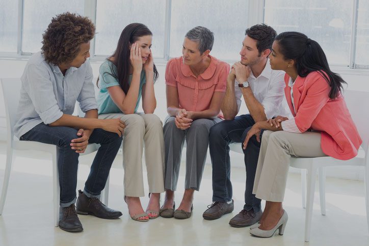 A group of people sitting in a circle talking.